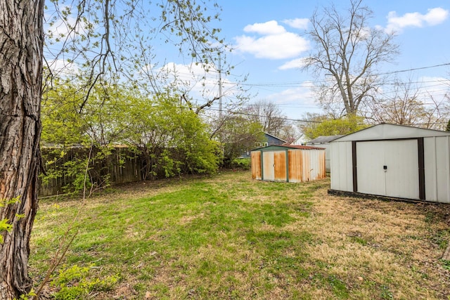 view of yard featuring fence, an outdoor structure, and a shed