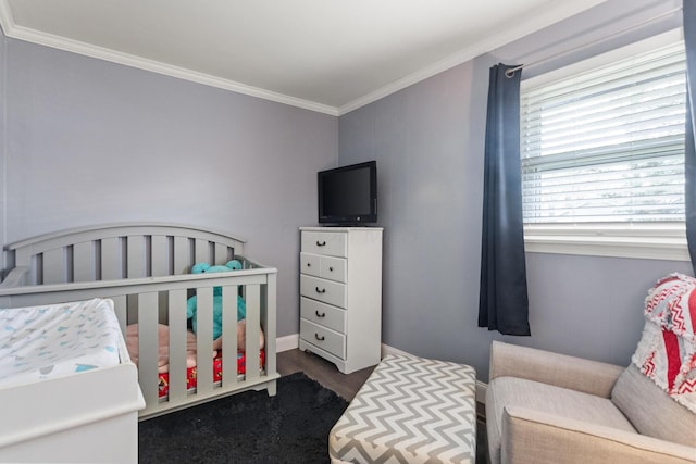 bedroom with crown molding and wood finished floors