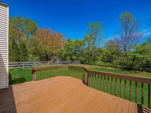 wooden deck with a yard, a fenced backyard, and a playground