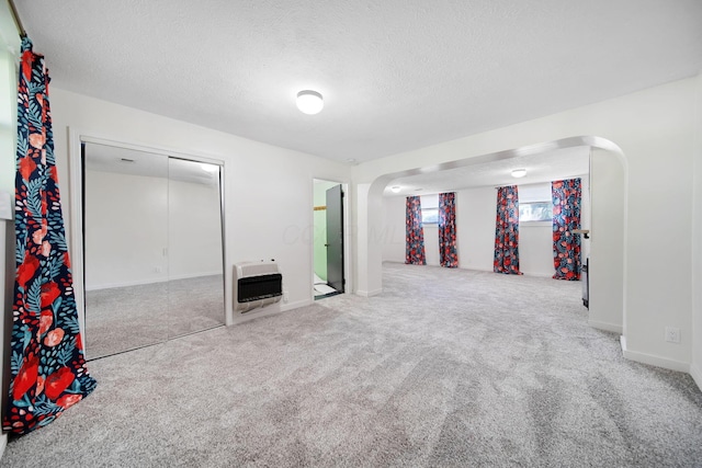 4959 Hughes Rd, Prospect, OH 43342 - below grade area featuring heating unit, arched walkways, carpet flooring, a textured ceiling, and baseboards