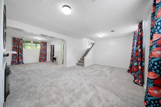 4959 Hughes Rd, Prospect, OH 43342 - basement featuring stairs, carpet, a textured ceiling, arched walkways, and baseboards