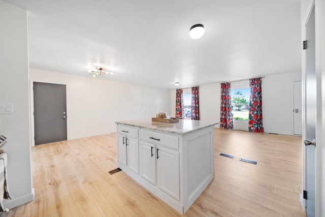 4959 Hughes Rd, Prospect, OH 43342 - kitchen with light wood-type flooring, white cabinets, a center island, and light stone countertops