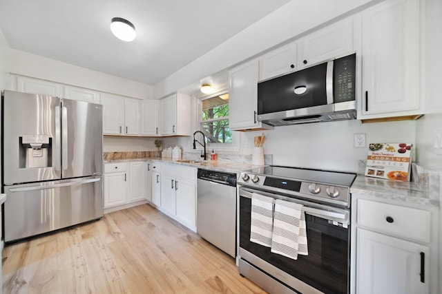 4959 Hughes Rd, Prospect, OH 43342 - kitchen with stainless steel appliances, a sink, white cabinets, light stone counters, and light wood finished floors