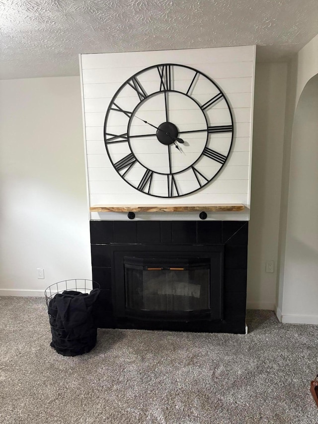 4959 Hughes Rd, Prospect, OH 43342 - detailed view of carpet flooring, a fireplace, a textured ceiling, baseboards, and arched walkways