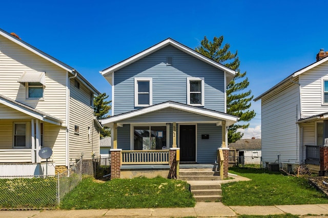 view of front facade with central AC, fence, a porch, and a front lawn