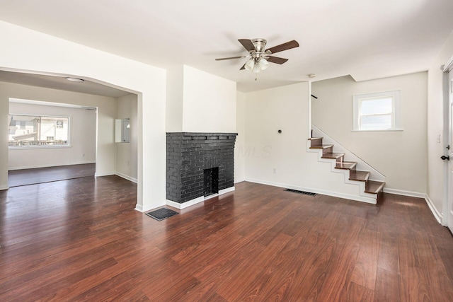 unfurnished living room with a wealth of natural light, visible vents, a ceiling fan, and stairs