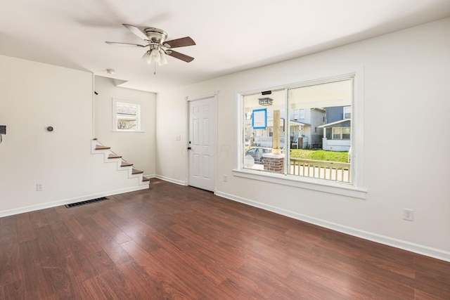 foyer entrance with stairway, visible vents, baseboards, wood finished floors, and a ceiling fan