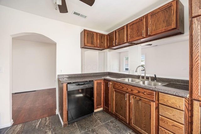 kitchen featuring visible vents, dark countertops, dishwasher, and a sink