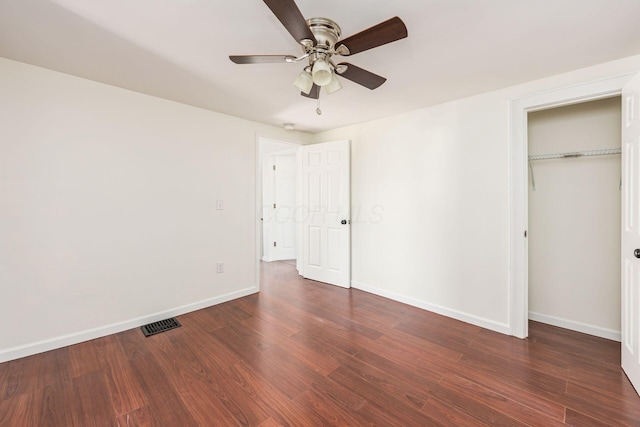 unfurnished bedroom with a closet, ceiling fan, visible vents, baseboards, and wood finished floors