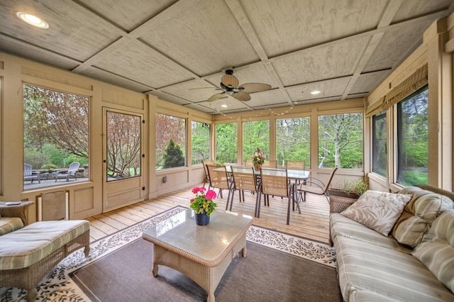 sunroom / solarium featuring coffered ceiling, ceiling fan, outdoor dining space, and an outdoor hangout area