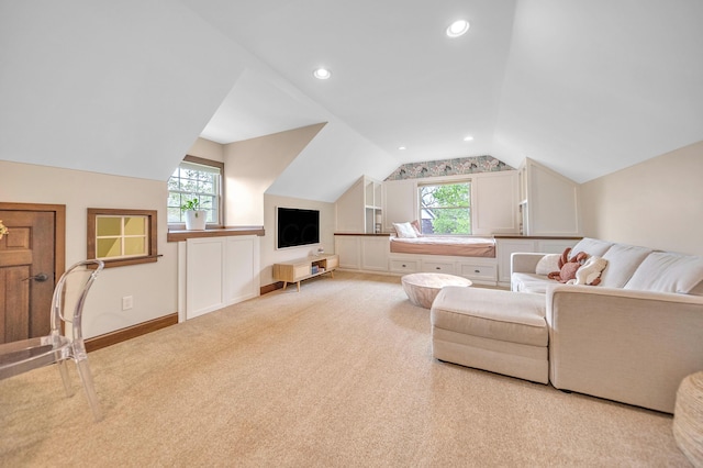 living room featuring light colored carpet, plenty of natural light, vaulted ceiling, and baseboards