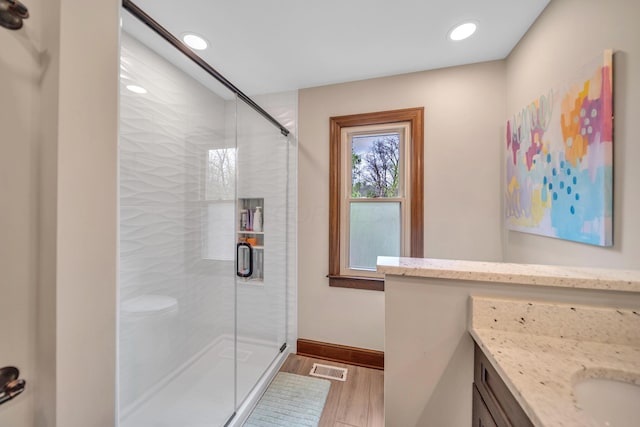bathroom with wood finished floors, vanity, recessed lighting, and a shower stall