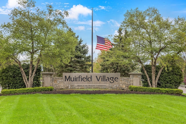 community / neighborhood sign with a yard