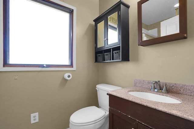 bathroom featuring toilet, plenty of natural light, and vanity