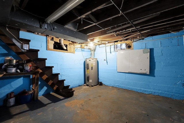 unfinished below grade area featuring stairs and electric water heater