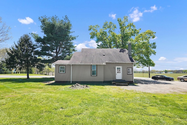 back of property featuring a lawn and a chimney