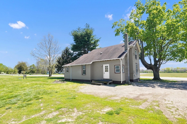 view of property exterior with a yard and driveway