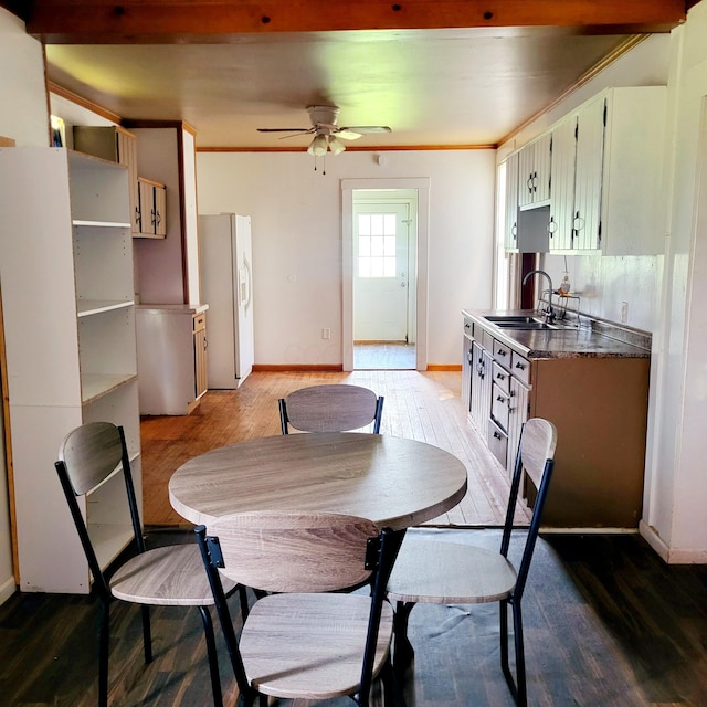 dining room with ceiling fan, ornamental molding, baseboards, and light wood-style floors