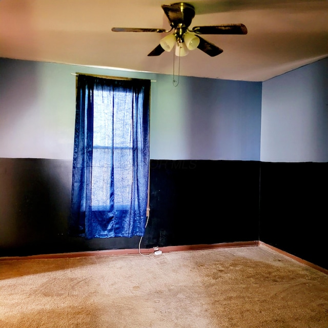 unfurnished room featuring carpet floors, ceiling fan, and baseboards