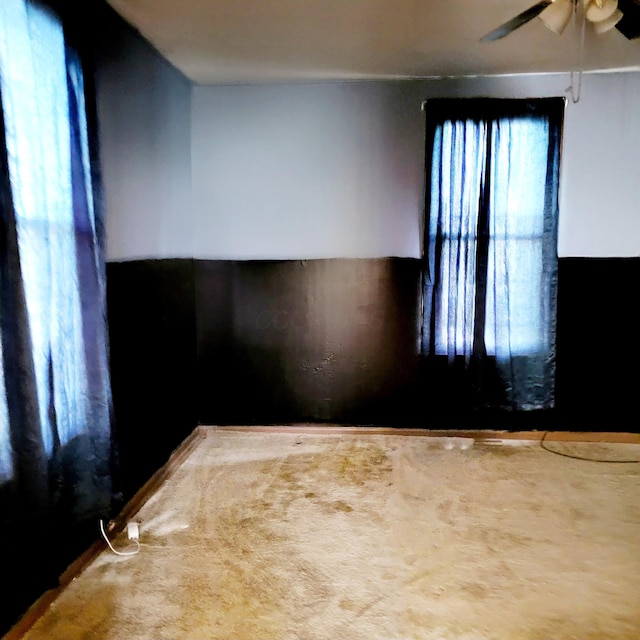 carpeted spare room featuring ceiling fan