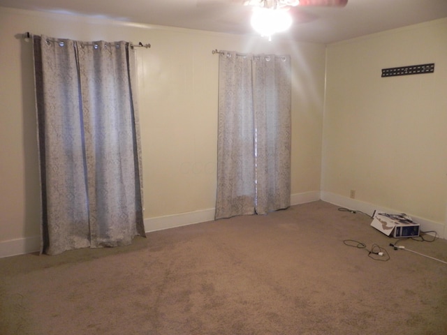 spare room with carpet floors, ceiling fan, and baseboards