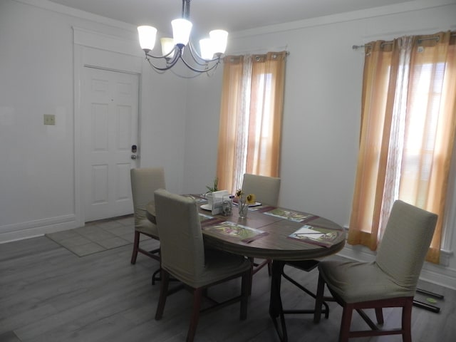 dining room with baseboards, a chandelier, and wood finished floors