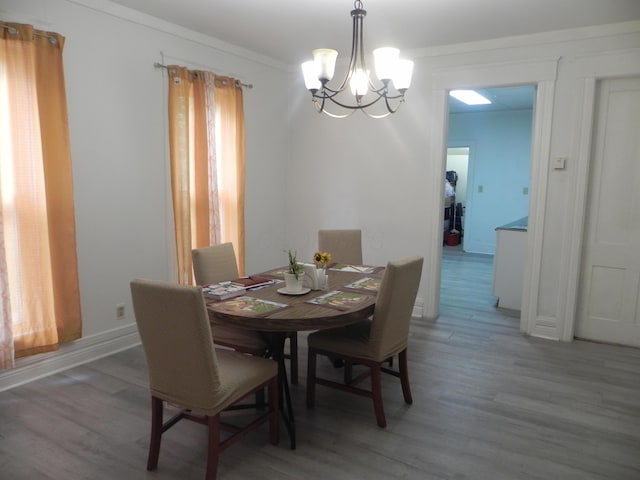 dining space featuring an inviting chandelier, crown molding, and light wood-type flooring