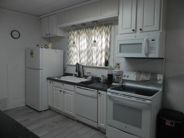 kitchen featuring backsplash, light wood-type flooring, a sink, white cabinets, and white appliances