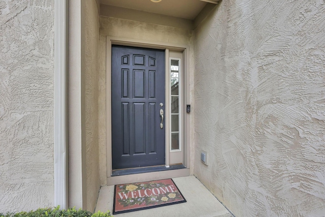entrance to property featuring stucco siding