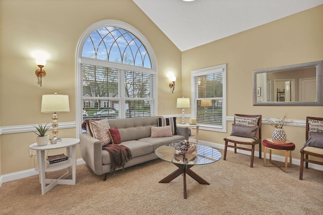 living area with carpet floors, baseboards, and high vaulted ceiling