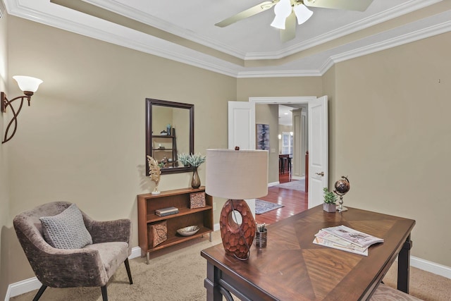 office area with a ceiling fan, baseboards, ornamental molding, and a tray ceiling