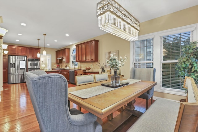 dining area featuring recessed lighting, light wood finished floors, and a chandelier