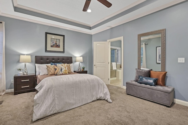 bedroom featuring crown molding, carpet floors, baseboards, a tray ceiling, and ensuite bath