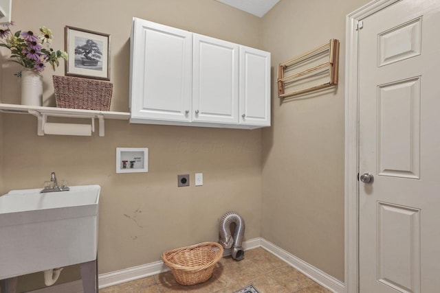 laundry area featuring electric dryer hookup, a sink, cabinet space, and baseboards