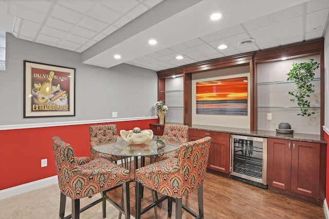 dining area featuring a drop ceiling, visible vents, beverage cooler, indoor bar, and dark wood-type flooring