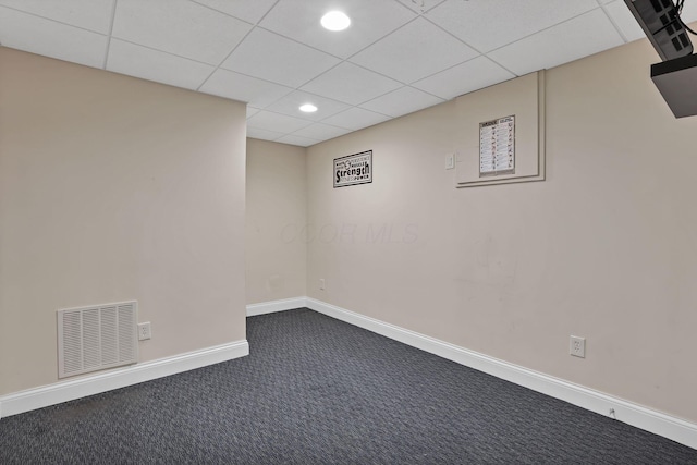finished below grade area with visible vents, baseboards, a drop ceiling, recessed lighting, and dark carpet