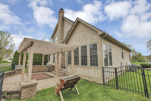 back of house featuring a lawn, exterior kitchen, fence, a patio, and stucco siding
