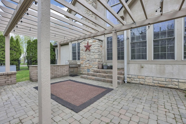 view of patio featuring a pergola, exterior kitchen, grilling area, and fence