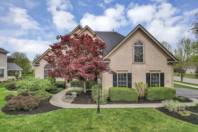 view of front of house with a front yard and stucco siding