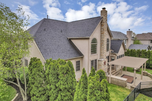 view of property exterior featuring a chimney, a shingled roof, and stucco siding