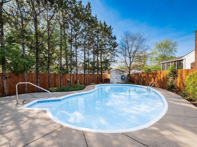 view of swimming pool featuring an outdoor structure, a fenced in pool, a fenced backyard, and a shed