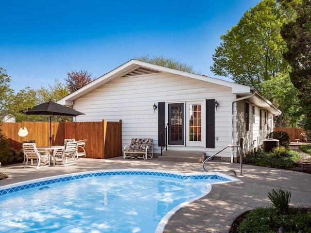 back of property featuring a fenced in pool, fence, entry steps, and a patio area