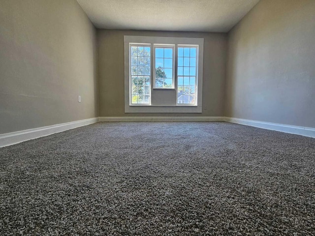 unfurnished room featuring baseboards, carpet flooring, and a textured ceiling
