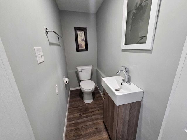 bathroom featuring vanity, baseboards, toilet, and wood finished floors