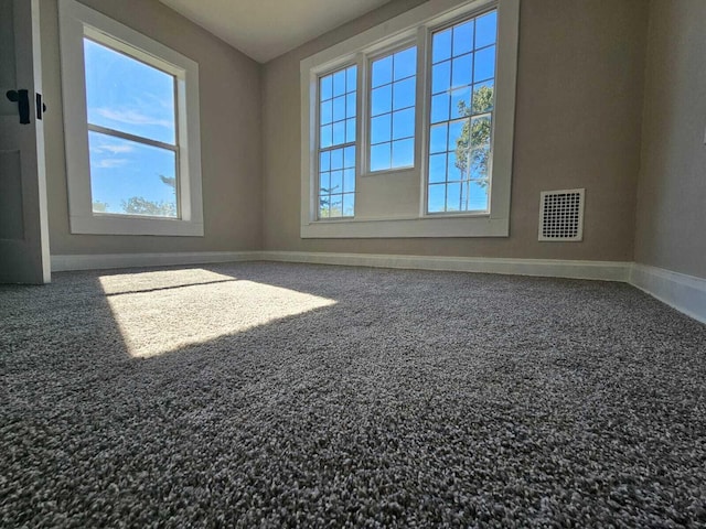 carpeted spare room with baseboards and visible vents