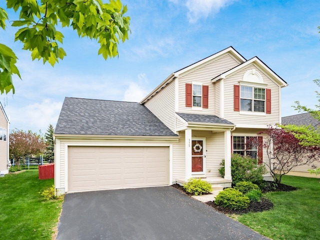traditional-style home featuring roof with shingles, a garage, a front yard, and aphalt driveway