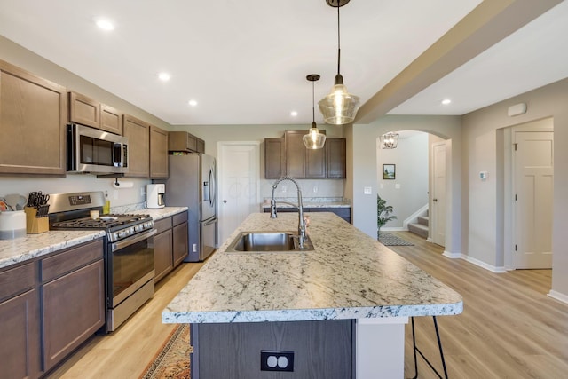 kitchen featuring a breakfast bar, light wood-type flooring, recessed lighting, a sink, and stainless steel appliances