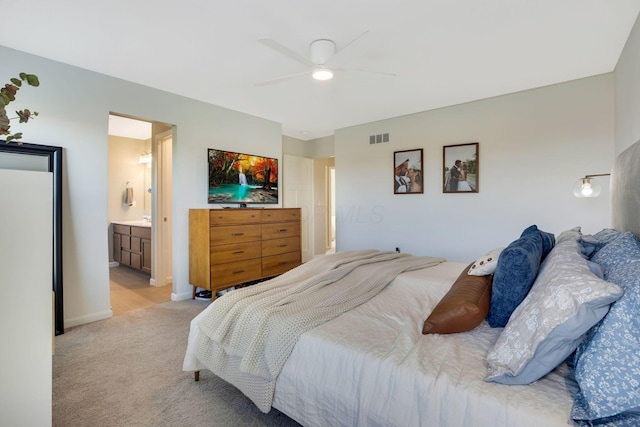 bedroom with visible vents, baseboards, light colored carpet, connected bathroom, and a ceiling fan