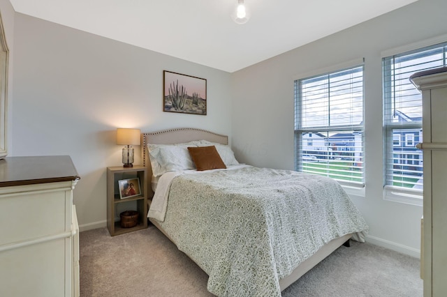 bedroom featuring baseboards and light colored carpet