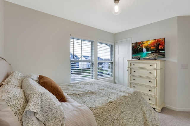 bedroom with baseboards and light carpet
